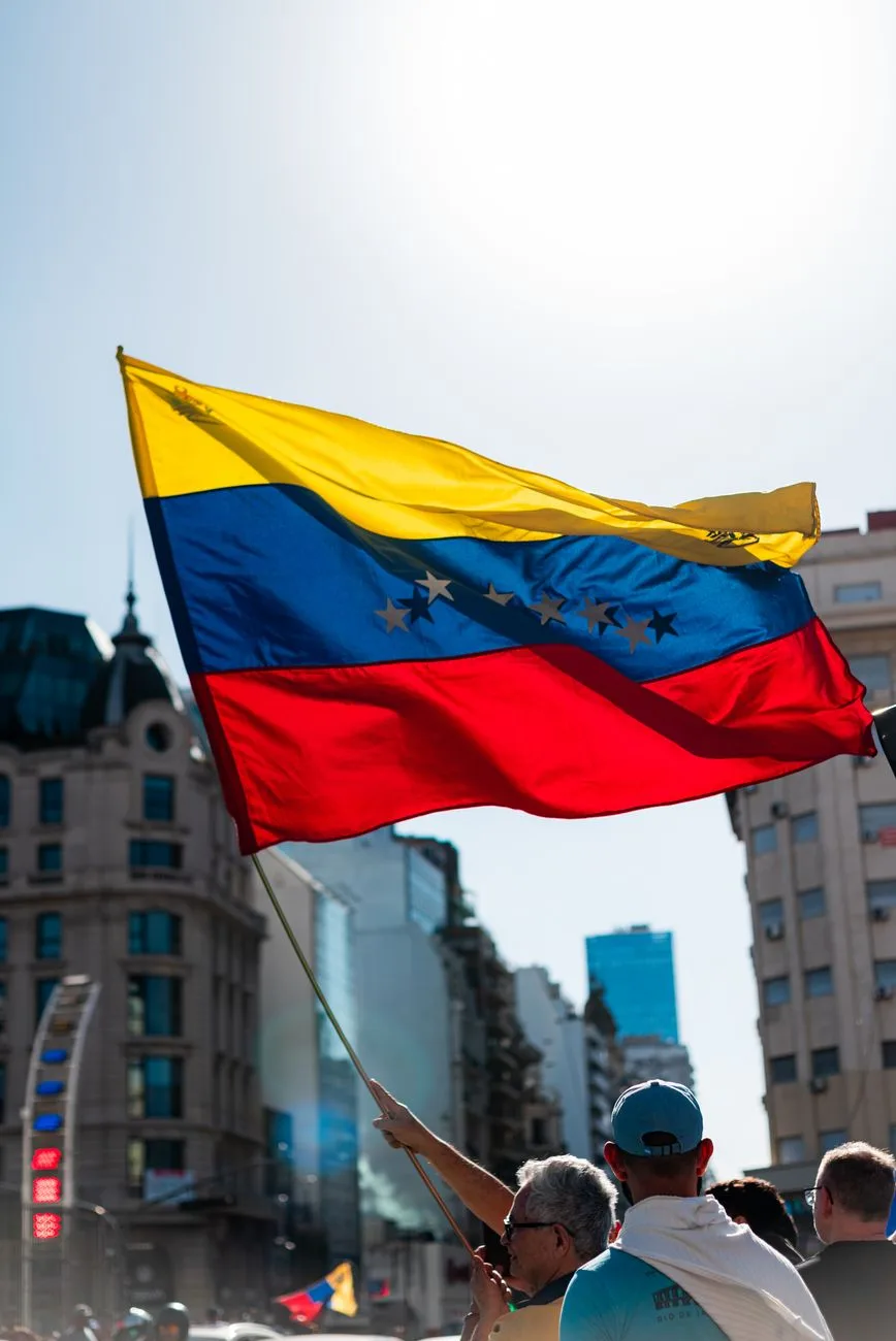 Una escena vibrante con la bandera venezolana ondeando durante un evento público en Buenos Aires.